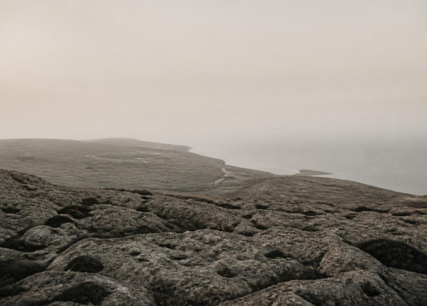 Quiet coastal terrain in muted stone tones